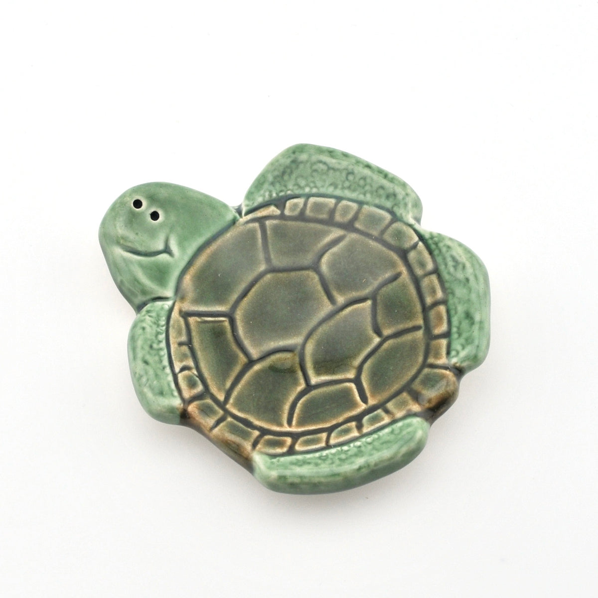 Green turtle-shaped object on a white background