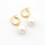 Gold hoop earrings with pearls on a white background